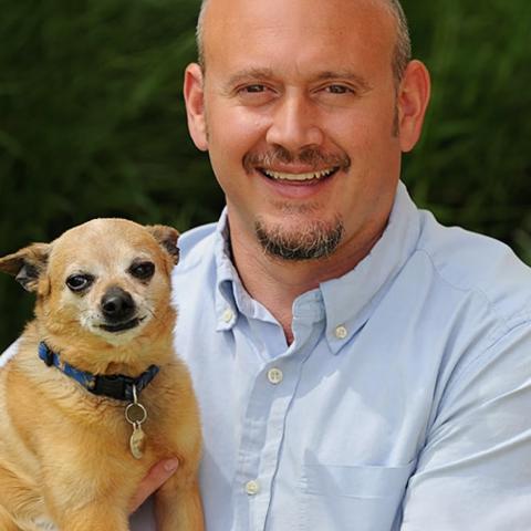 Judah Battista holding small tan dog