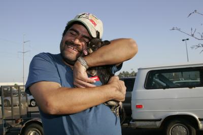 Person smiling and hugging a small dog after Hurricane Katrina